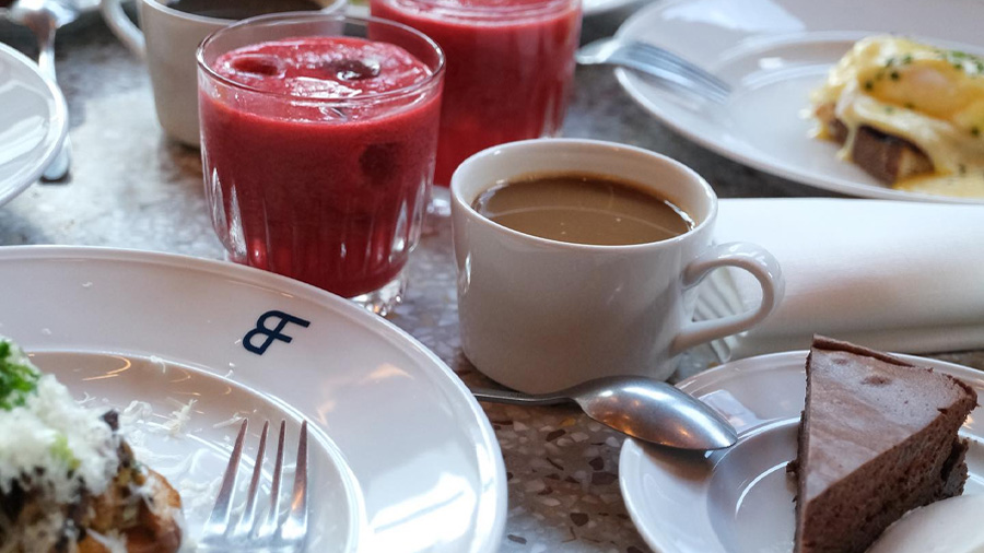 Närbild på brunchrätt, en smooothie och chokladkaka