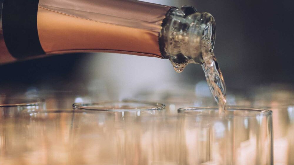 Någon häller upp champagne i glas