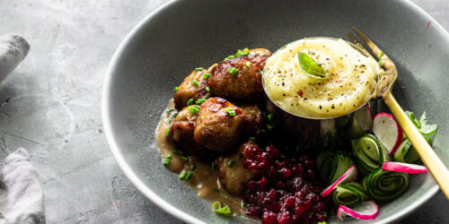 En tallrik med köttbullar, potatismos, gräddsås och lingonsylt