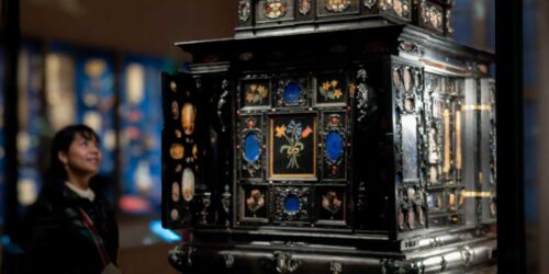 Kvinna kolla på en museemonter med Konstskåpet, Gustavianum, Uppsala