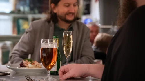 Två kompisar äter och dricker i en saluhall