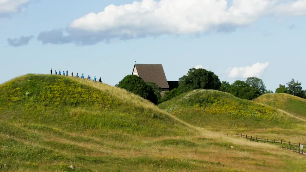 Personer går på Gamla Uppsala högar