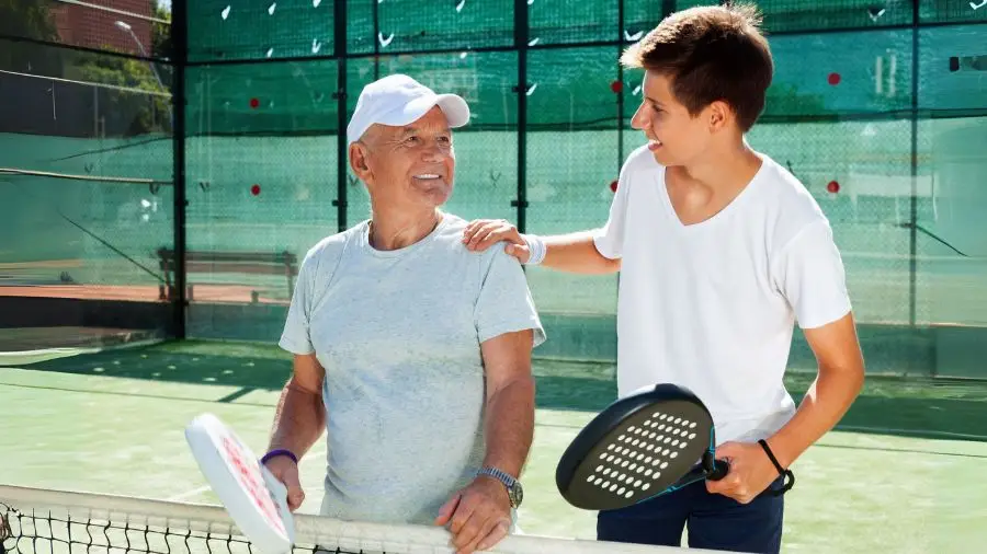 man och kille spelar padel