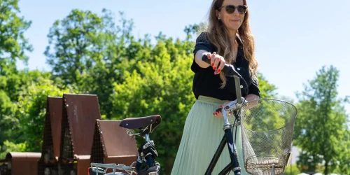 Kvinna leder en cykel i Uppsalas parker