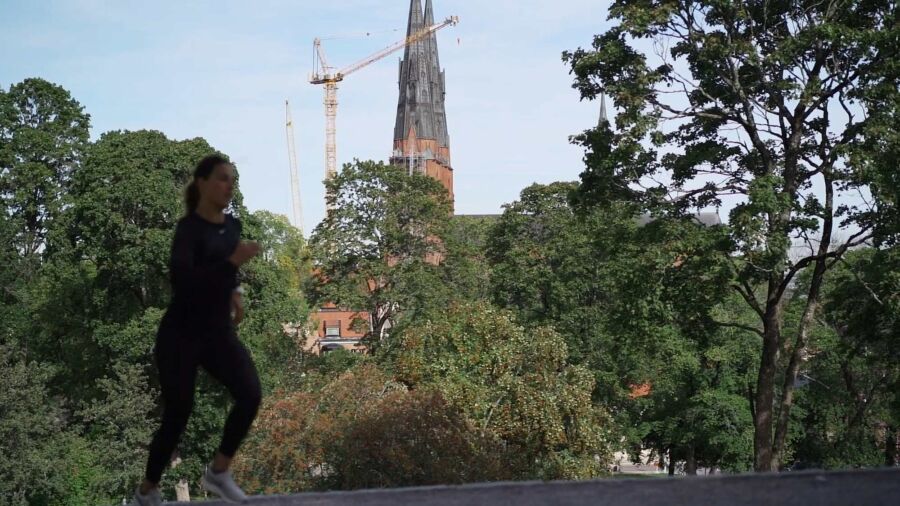 Kvinna springer med vy över Uppsala
