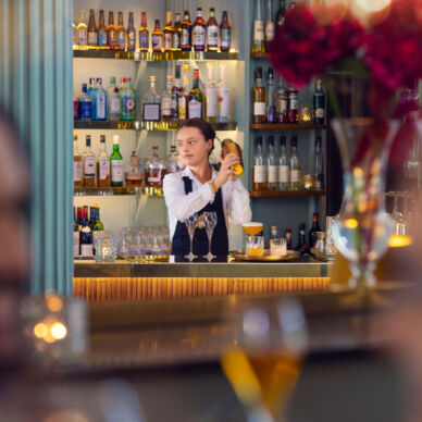 En bartender skakar en drink bakom bardisk