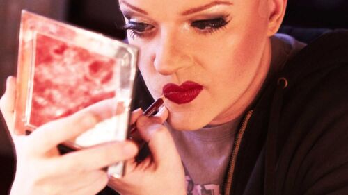 En dragqueen lägger smink i teaterloge