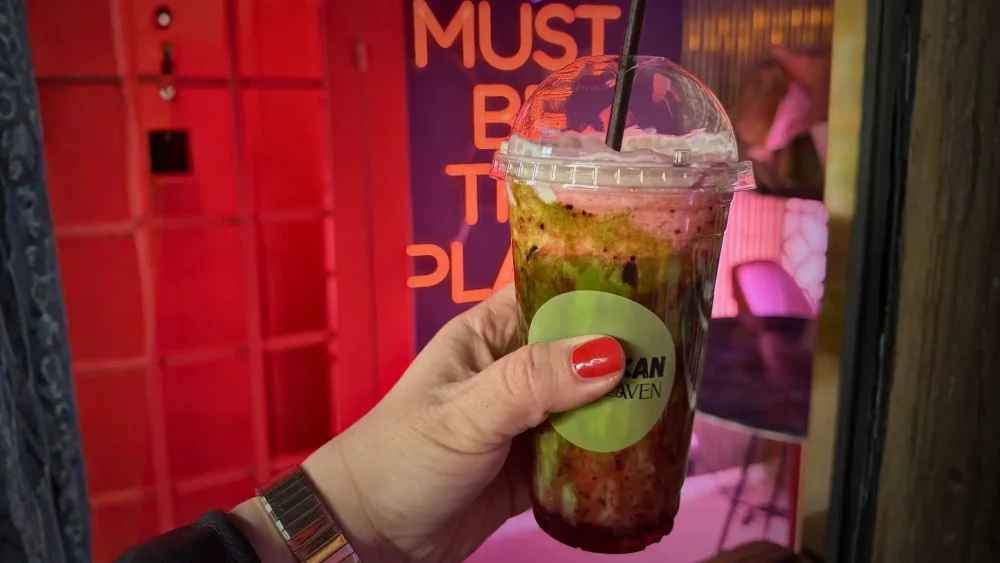 Person håller i en take away matcha latte
