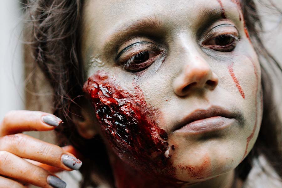 Närbild på kvinna i zombie-smink