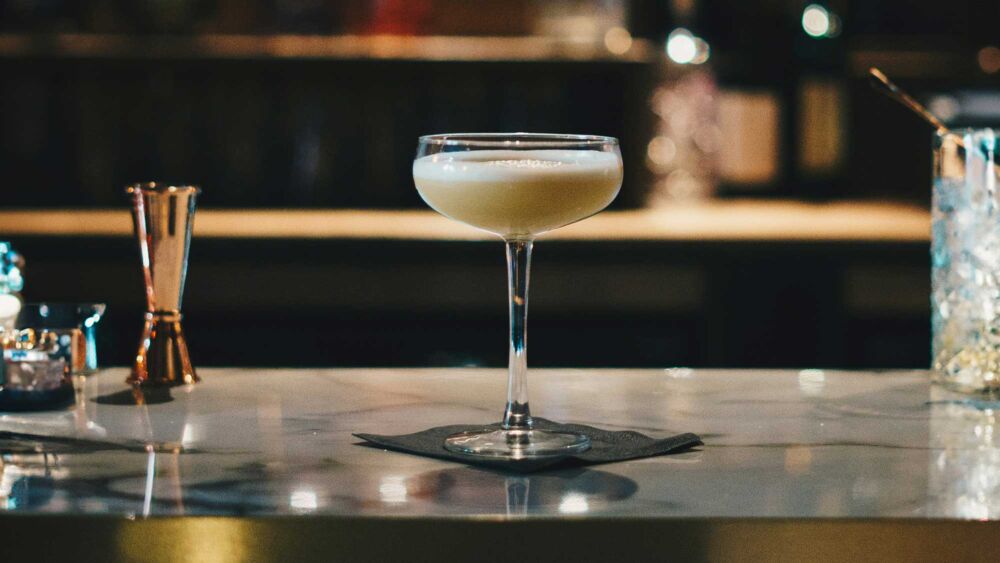 En gul cocktail på en bardisk