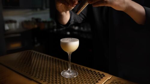 Bartender river kryddor över en drink