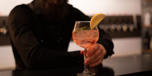 En bartender håller fram en GT-drink