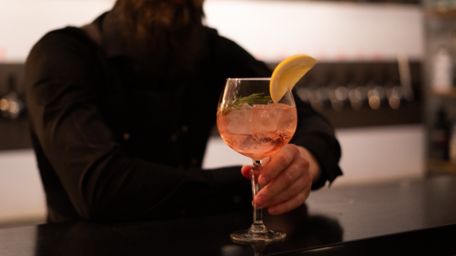 En bartender håller fram en GT-drink