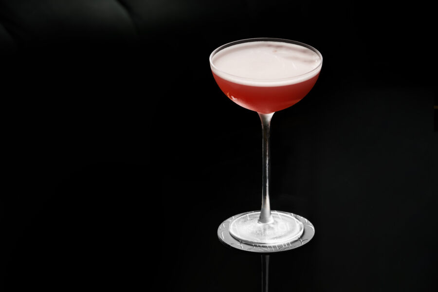En röd drink på svart glasbord