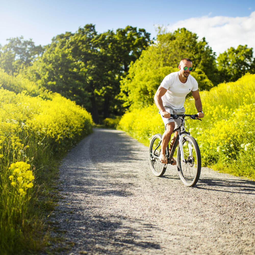 Man som cyklar på grusväg