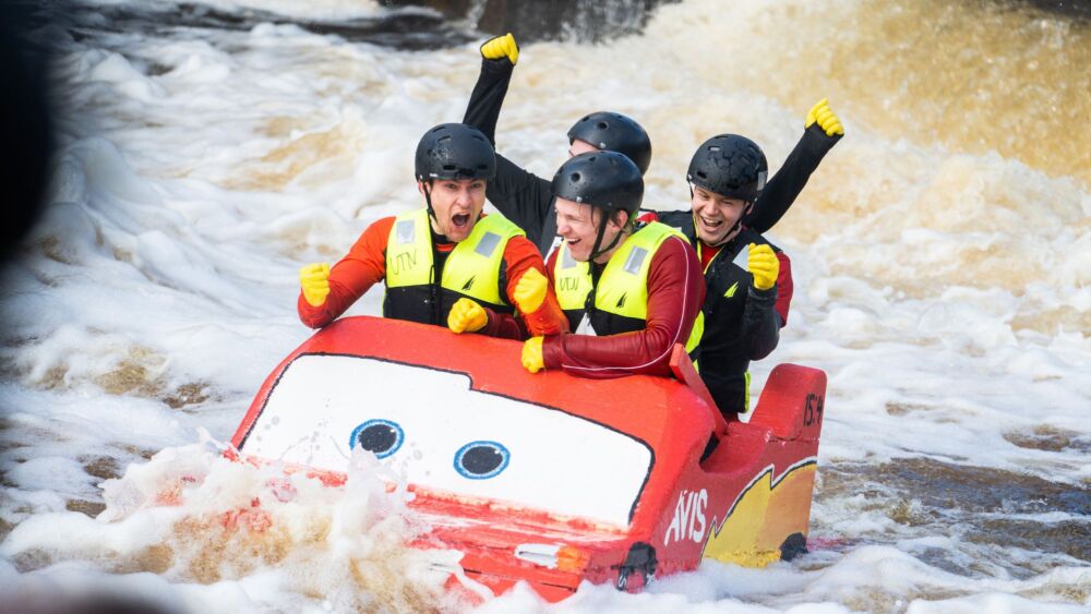 Studenter på en flotte som ser ut som en bil under forsränningen på Valborg