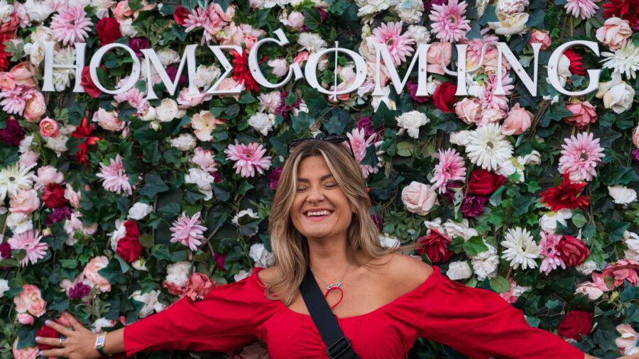 Kvinna vid selfiewall med blommor