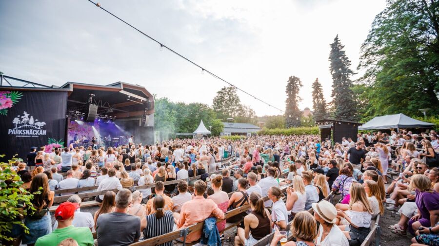 Bild på publik framför en utomhusscen under en sommarkväll