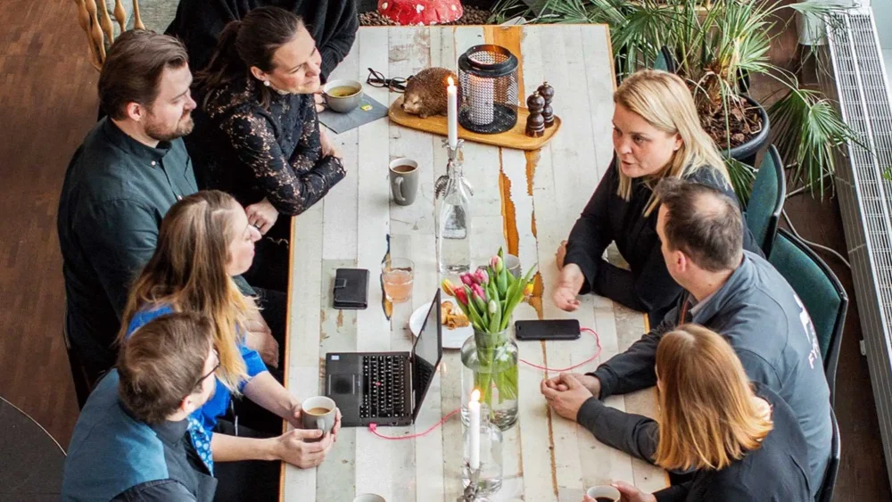 Människor sitter runt ett bord och har möte