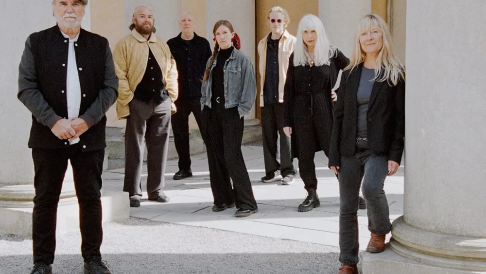 Artister står vid ett hus