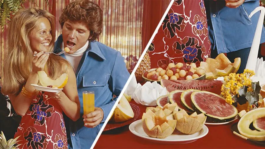 En 70-talsbild där en kvinna håller upp en gaffel till en man