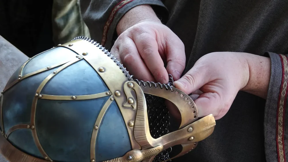 Händer som gör hantverk med vikingahjälm