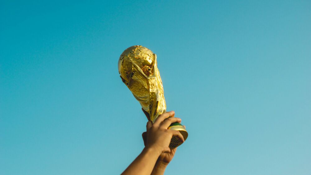 Händer som håller upp pokal