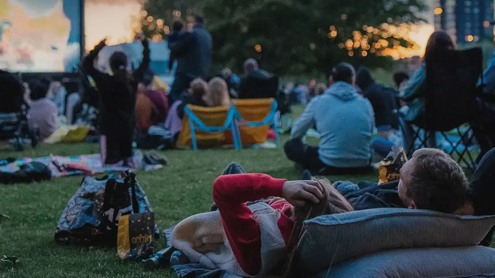 Personer tittar på bio i en park