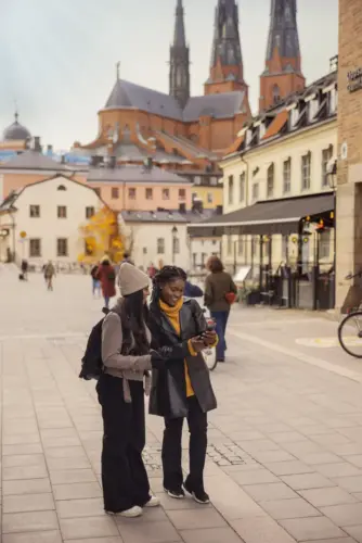 Några kvinnor som står bredvid varandra på en gata i Uppsala