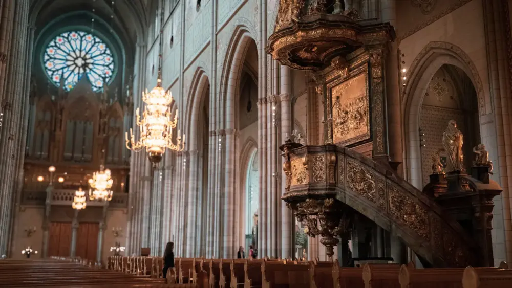 En stor katedral med predikstol och ljuskronor.